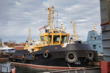 Fototapeta premium Tugboats and other marine support vessels in port.