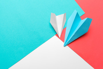 Flat lay of white paper plane and blank paper on pastel blue color background