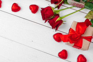 Fototapeta na wymiar St. Valentines Day. Red roses and gift box on wooden table