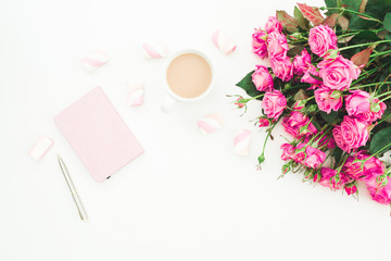Female desk with pink roses bouquet, diary, coffee mug and marshmallows on white background. Flat lay. Top view