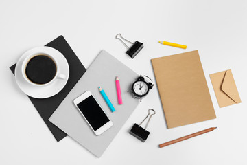 Smartphone and coffee cup, notepad close up top view