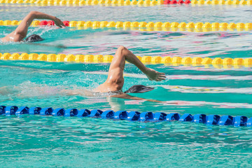 Movement of athletic  swimmers swimming freestyle stroke front crawl or forward crawl during competition in to the pool