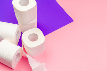 White toilet paper rolls on bright color block background