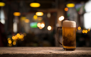 Glasses with cold beer on table against blurred background