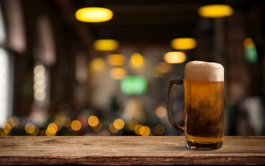 Glasses with cold beer on table against blurred background