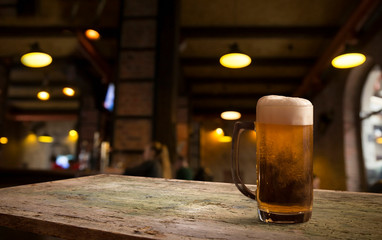 Glasses with cold beer on table against blurred background