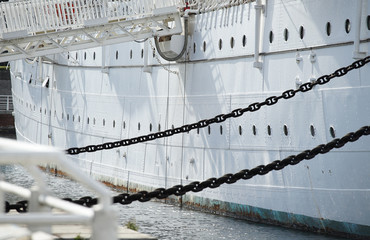 The hull of the white sailing boat anchoring in the port of the day when it was fine