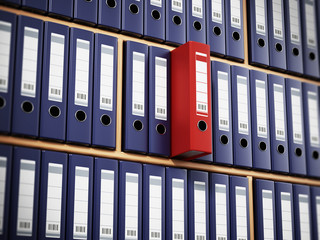 Red folder standing out among black ones inside wooden shelves. 3D illustration
