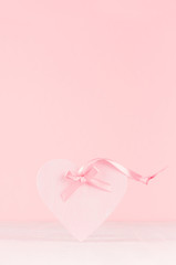 Romance celebration background for Valentine and wedding - cute heart with silk ribbon on white wood board, copy space.