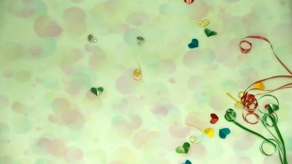 Colourful heart shape ribbon with small gift boxes on colorful bokeh, flare background.