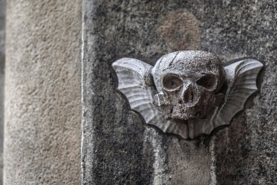 Vienna, Austria - December 30, 2017. Carved stone scull with wings on old church facade wall. Decorative bas-relief sculpture depicts winged mortality sign, life and death old religious symbol.