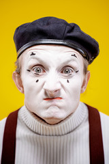 Close-up portrait of an actor as a pantomime with white facial makeup showing expressive emotions...
