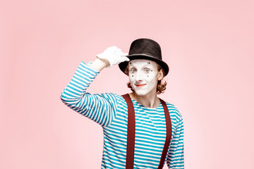 Portrait of an actor as a pantomime with white facial makeup posing with expressive emotions on the...