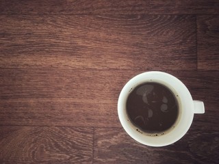 Obraz premium Hot 3 in 1 coffee with bubbles in white cup on wooden table.