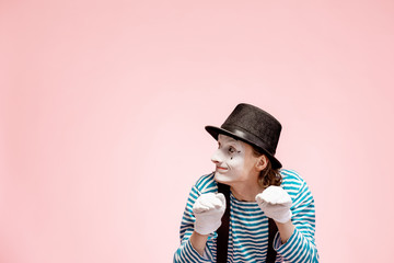 Portrait of an actor as a pantomime with white facial makeup posing with expressive emotions on the...
