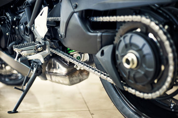 View of the back of a motorcycle with an emphasis on the chain.