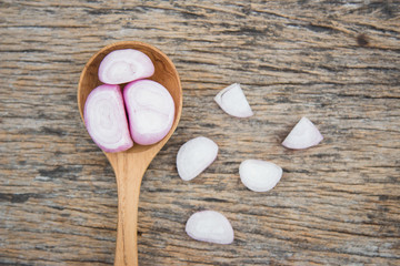 Peeling red shallot on wooden spoon for healthy eating 