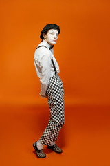 Full length portrait of an actor as a pantomime with white facial makeup showing expressive...