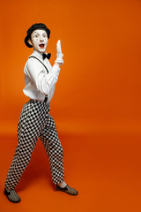 Full length portrait of an actor as a pantomime with white facial makeup showing expressive...