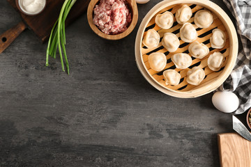 Obraz na płótnie Canvas Steamer with tasty dumplings and ingredients on table