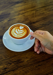 Hand Holding Coffee Cup On Table