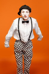 Portrait of an actor as a pantomime with white facial makeup showing expressive emotions on the...