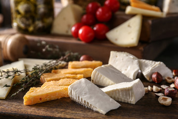 Assortment of tasty cheese on wooden board