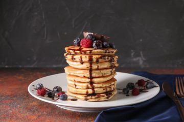 Tasty pancakes with passion fruit and berries on table