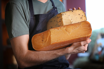 Male seller with delicious cheese in store