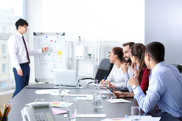 Young Asian businessman giving presentation in office