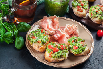 Bruschetta with fresh pesto, mozzarella and cherry tomatoes on a plate
