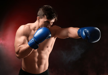 Plakat Attractive young boxer on dark background