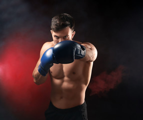 Fototapeta na wymiar Attractive young boxer on dark background