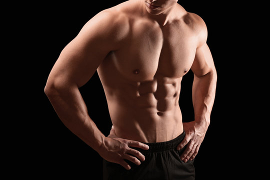 Muscular bodybuilder on dark background