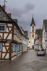 narrow cobbled street with beautiful half-timbered houses and an old cathedral in the town square