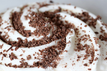 Grated dark chocolate on ice cream close up. Tasty creamy dessert