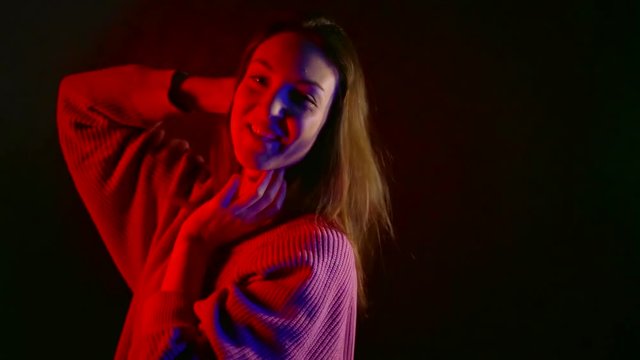 happy Asian girl fun moves in dark room in red neon light