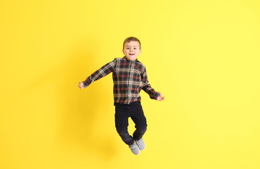 Obraz premium Jumping little boy on color background