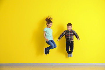 Fototapeta na wymiar Jumping little children on color background