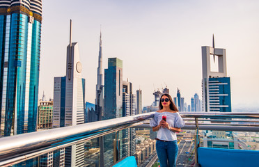 Woman having a drink with Dubai city view