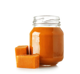 Jar with sweet liquid caramel on white background