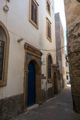 Fototapeta na wymiar Narrow street, old doors and colorful old houses of medieval medina of Essaouira, Morocco