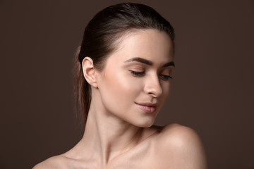 Young woman with beautiful eyebrows on color background