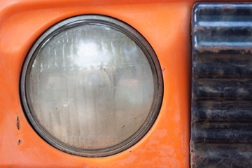 Car headlights on orange frame.