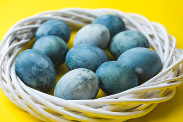Hand painted blue Easter eggs in wreath on bright yellow background. The concept of spring holiday of Easter.