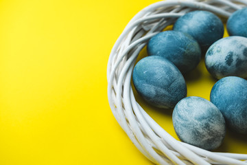 Hand painted blue Easter eggs in wreath on bright yellow background. The concept of spring holiday of Easter.
