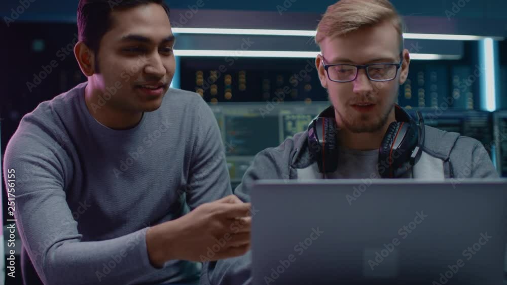 Aufkleber gaming software delevoper talks with it enginer, discussing project desing shown on laptop. in the b