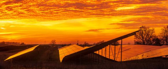 Fototapeta na wymiar Solar power plant on the background of dramatic, fiery sky at sunset,Germany