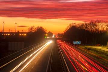 Fototapeta na wymiar the light trails on motorway highway during a dramatic sunset