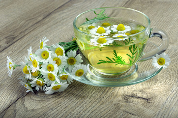 Obraz na płótnie Canvas cup of chamomile tea on a wooden table. herbal tea. vitamins tea